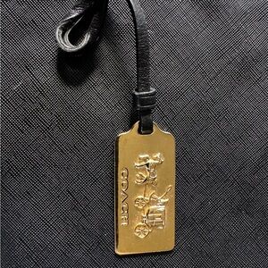 Coach gold metal tag with black leather strap